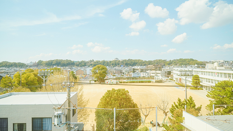 沿線から望む緑の丘と街並み